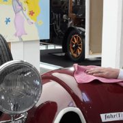 Dame poliert und pflegt einen Oldtimer von fahr(T)raum