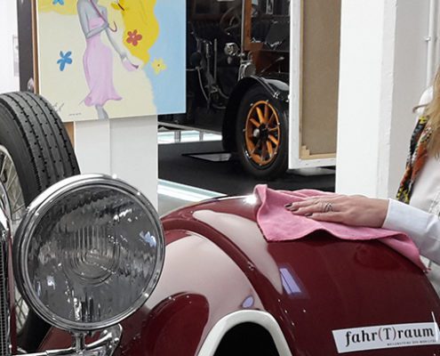 Dame poliert und pflegt einen Porsche Oldtimer von fahr(T)raum