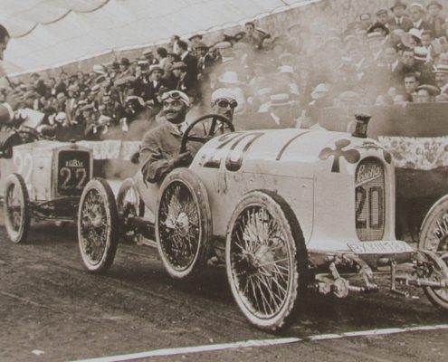 Zwei Männer an der Startlinie eines Rennens zur Anfangszeit des Motorsports 